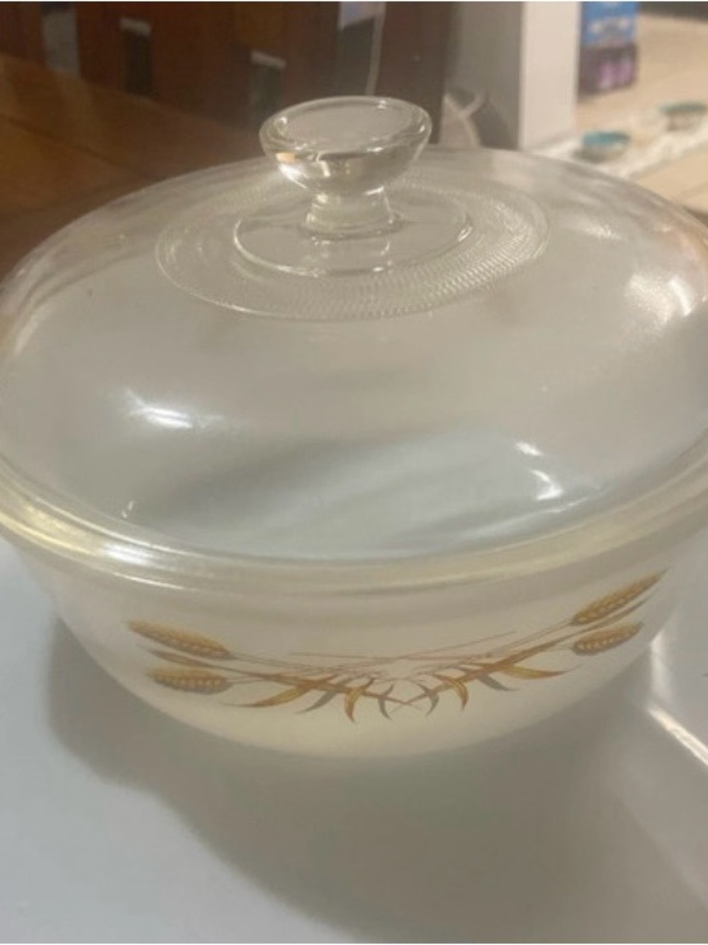 Anchor Hocking Fire King golden wheat casserole dish with clear lid.